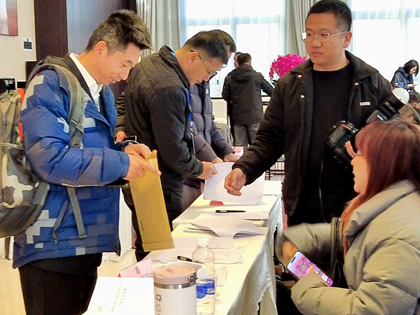 報到現(xiàn)場，委員們領(lǐng)取會議資料。實習(xí)記者_(dá)(1457413)-20250217085643.png